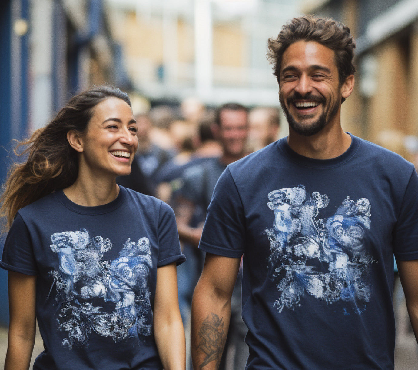 a man and woman walking together in matching t-shirts smiling